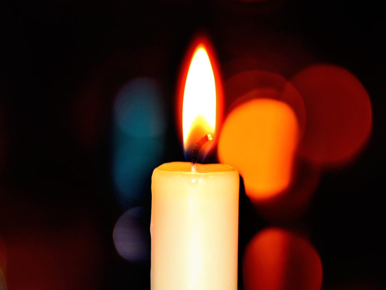 white candle in bokeh photography